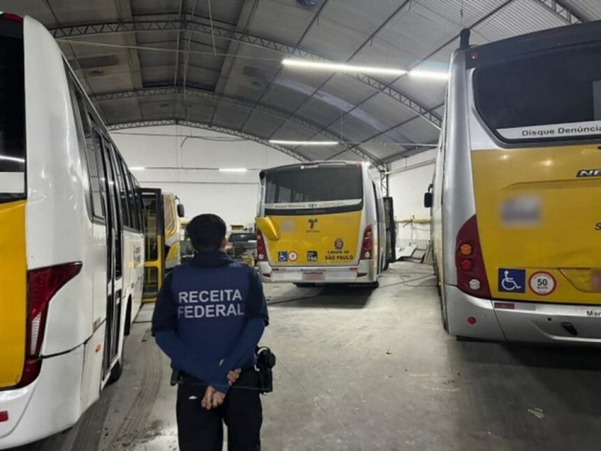Agente da Receita Federal em garagem com ônibus do sistema municipal de São Paulo