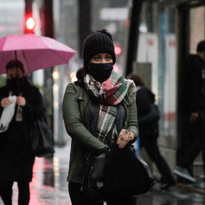 Pedestres se protegem do frio e da chuva na Avenida Paulista, em SP