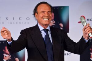 Julio Iglesias segura microfone durante aparição pública