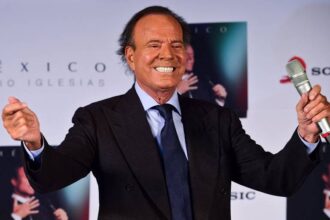 Julio Iglesias segura microfone durante aparição pública