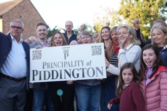 Moradores de Piddington seguram placa com a inscrição Principality of Piddington
