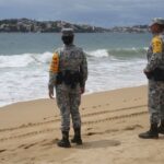 Membros da Guarda Nacional em praia como parte do plano de socorro em desastres, enquanto o furacão Polo ganha força na costa do Pacífico do México