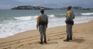 Membros da Guarda Nacional em praia como parte do plano de socorro em desastres, enquanto o furacão Polo ganha força na costa do Pacífico do México