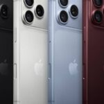Quatro smartphones de costas, alinhados diagonalmente da esquerda para a direita, em fundo preto. Da esquerda para a direita: um telefone preto, um branco, um azul claro e um vermelho escuro. Todos exibem o logo da maçã no centro e três lentes de câmera no canto superior esquerdo