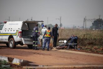 Policiais e peritos trabalham no local onde o corpo de uma mulher foi encontrado em Boksburg, na África do Sul