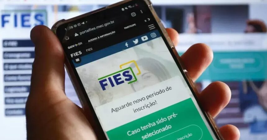 mão segura celular aberto na páfina do Fies