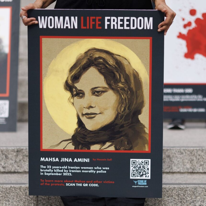 Cartaz de Mahsa Amini, uma iraniana de 22 anos que morreu inesperadamente em 16 de setembro de 2022, sob custódia policial no Irã, após supostamente violar as regras do país sobre o hijab • Dan Kitwood/Getty Images