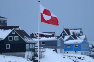 A bandeira da Groenlândia tremula sobre casas em 17 de janeiro de 2026 em Nuuk, Groenlândia. Líderes da Groenlândia