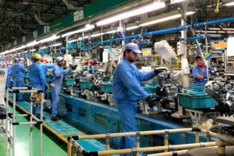 Trabalhadores atuam em linha de produção industrial