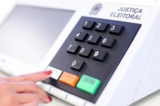 Eleitora pressiona a tecla branco em uma urna eletrônica