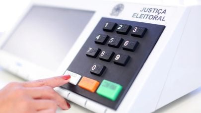 Eleitora pressiona a tecla branco em uma urna eletrônica