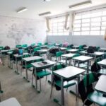 Foto mostra carteiras e cadeiras em sala de aula
