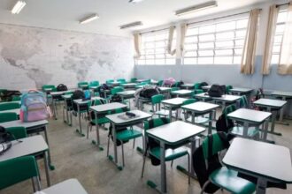 Foto mostra carteiras e cadeiras em sala de aula