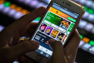 Mão segurando um celular cuja tela exibe um aplicativo de cassino online