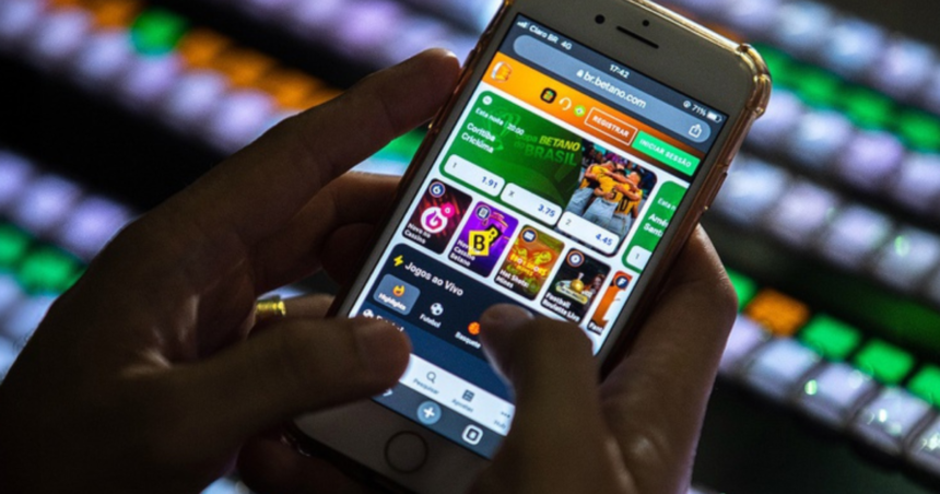 Homem utilizando aplicativo de apostas online em um smartphone