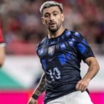 Jogador Arrascaeta em campo vestindo a camisa da seleção