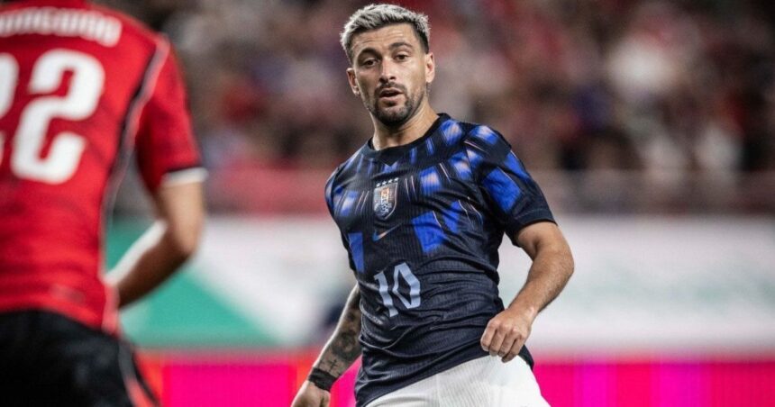 Jogador Arrascaeta em campo vestindo a camisa da seleção