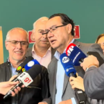 Augusto Cury fala a jornalistas, cercado por microfones, durante visita ao Instituto Baccarelli, em São Paulo.