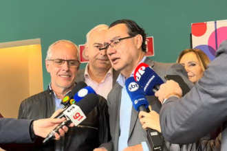 Augusto Cury fala a jornalistas, cercado por microfones, durante visita ao Instituto Baccarelli, em São Paulo.