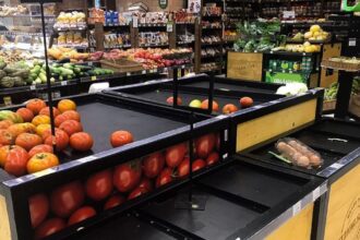 Carrinho de supermercado cheio de compras representando o impacto da inflação.