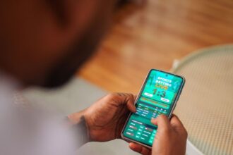 Pessoa usa smartphone para apostas esportivas
