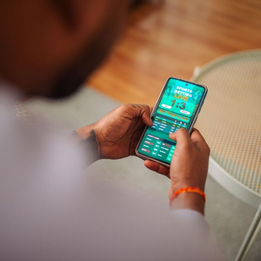 Pessoa usa smartphone para apostas esportivas