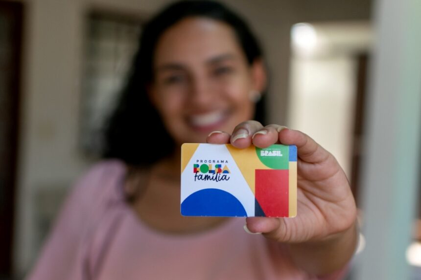 Beneficiária segura cartão do programa Bolsa Família