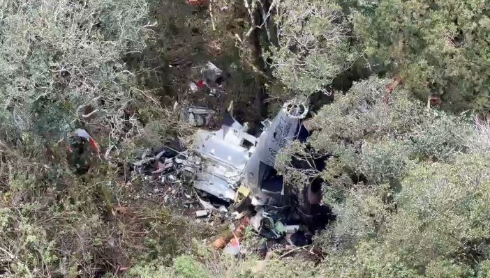 Destroços de helicóptero em área de mata