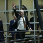 Julian Assange acena após chegar à Austrália
