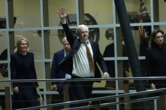 Julian Assange acena após chegar à Austrália