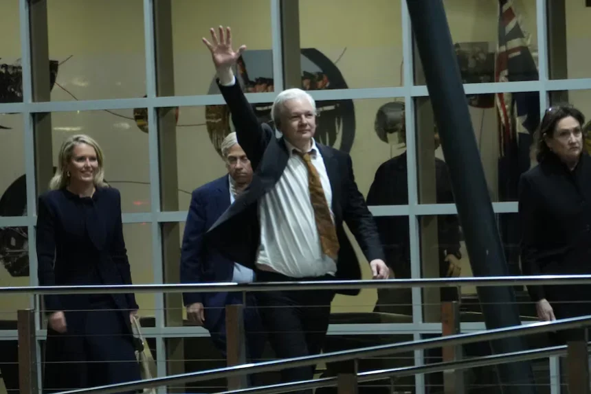 Julian Assange acena após chegar à Austrália