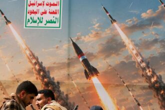 Houthis diante de banner que retrata mísseis em manifestação contra a Arábia Saudita, em Sanaa, no Iêmen