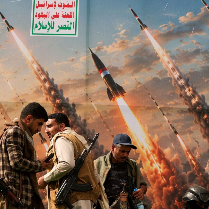 Houthis diante de banner que retrata mísseis em manifestação contra a Arábia Saudita, em Sanaa, no Iêmen
