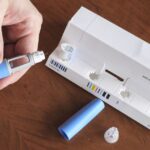 Frasco de medicamento e caneta aplicadora em ambiente neutro