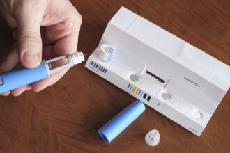 Frasco de medicamento e caneta aplicadora em ambiente neutro