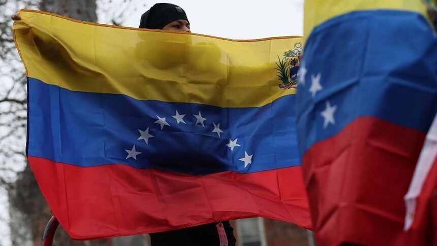 Pessoas seguram bandeiras da Venezuela em frente ao Tribunal Federal Daniel Patrick Moynihan, antes da audiência de acusação do ditador da Venezuela, Nicolás Maduro, e da primeira-dama, Cilia Flores, em 5 de janeiro de 2026, na cidade de Nova York.