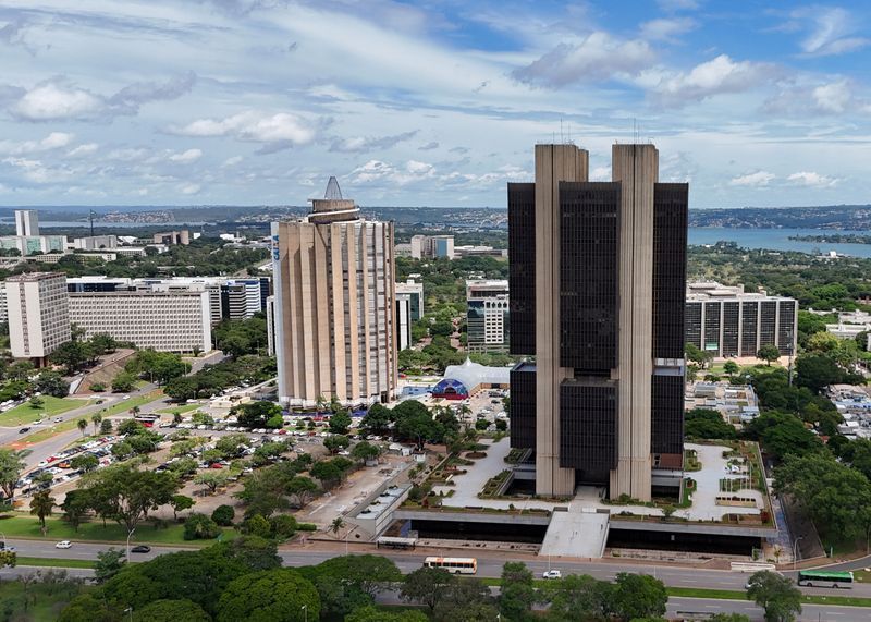 Sede do Banco Central aparece em imagem tirada de longe. O edifíco possui duas colunas brancas e um centro mais escuro, ficando em destqqeu em meio ao resto da cidade que tambpem aparecem na foto