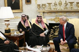 Bandeiras dos Estados Unidos e da Arábia Saudita diante de instalação nuclear