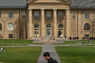 Estudantes em frente ao Goldwin Smith Hall, no campus da Universidade Cornell em Ithaca, Nova York, em abril de 2023