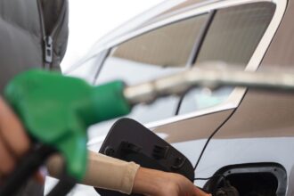 Vista da mulher com carro no posto de gasolina