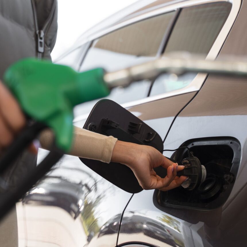 Vista da mulher com carro no posto de gasolina