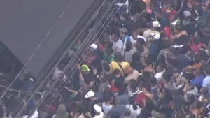 Movimento de pedestres e veículos em rua comercial de São Paulo