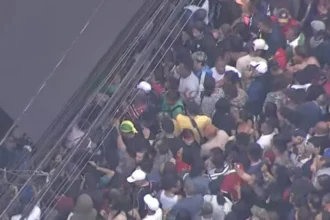 Movimento de pedestres e veículos em rua comercial de São Paulo